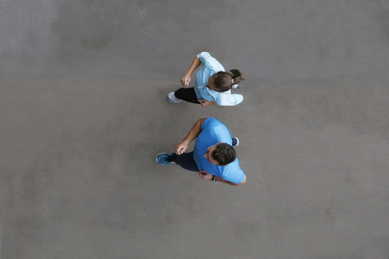 a couple of people sitting on top of a tennis court, by Ludovit Fulla, shutterstock, conceptual art, wearing a light blue shirt, street top view, running sequence, stock photo
