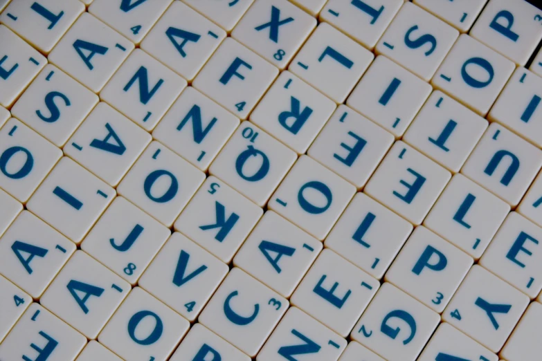 a pile of white tiles with blue writing on them, a mosaic, pixabay, alphabet soup, language, board games, zoomed in