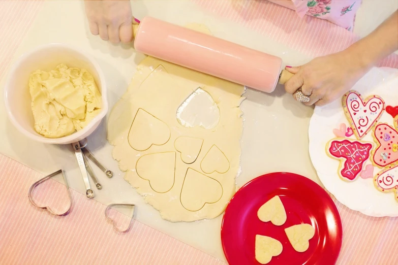 a close up of a person making cookies on a table, inspired by Annabel Kidston, several hearts, product introduction photo, catalog photo, cutout