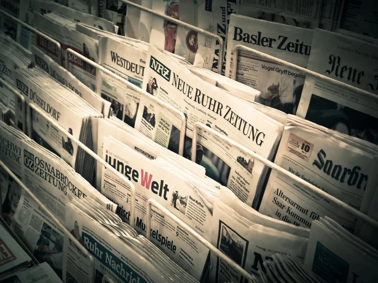 a bunch of newspapers stacked on top of each other, a picture, by Matthias Weischer, pexels, retro style ”, ears, backlit, wide angle”