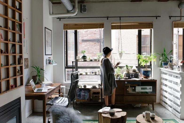 a woman standing in a living room next to a window, process art, open office, on desk, interior of a loft, :: morning