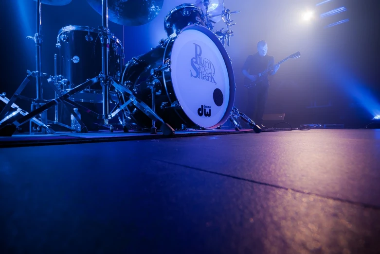 a drum kit sitting on top of a stage, a portrait, by Dicky Doyle, shutterstock, purism, wide angle dynamic action shot, spirits, zoomed in shots, soft spot light