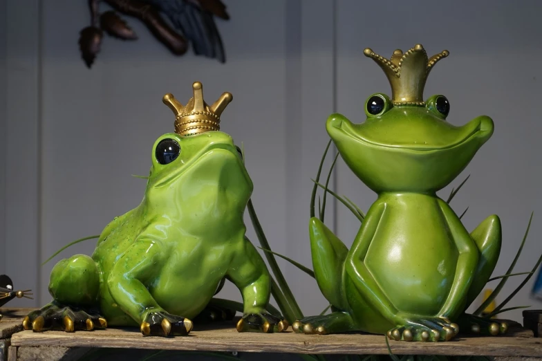 a couple of green frogs sitting on top of a wooden table, pixabay, renaissance, like a crown, fiberglass, high res photo, close-up photo