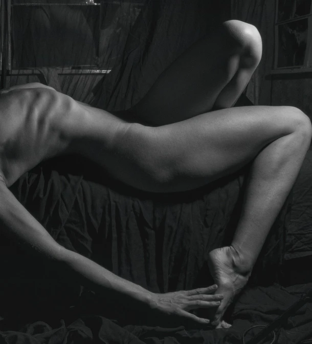 a naked woman laying on a bed next to a window, inspired by Peter Basch, dirk dzimirsky, close-up on legs, in dark room, arched back