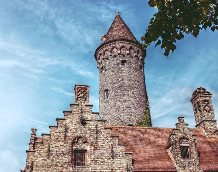 a tall brick building with a clock tower, a colorized photo, by Jakob Gauermann, pexels, romanesque, сastle on the rock, tallinn, twisted giant tower, summer