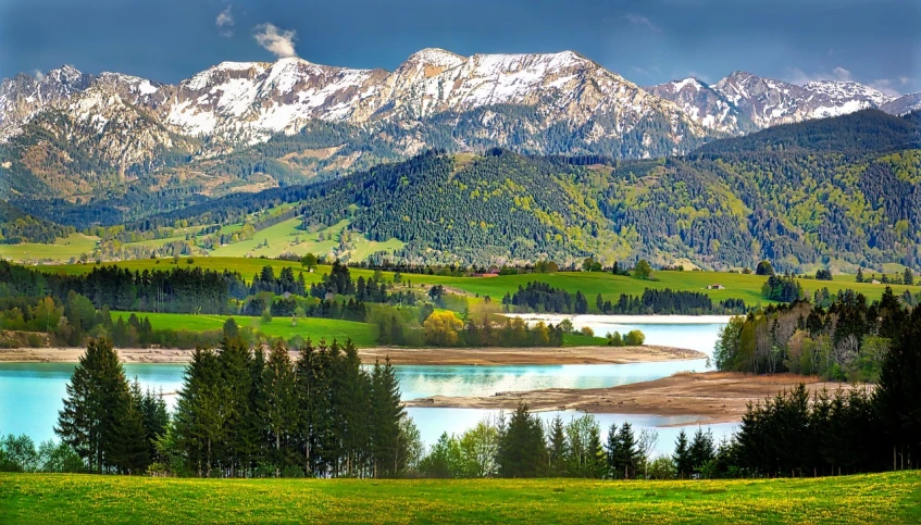 a view of a mountain range with a lake in the foreground, a stock photo, by Franz Hegi, shutterstock, fine art, springtime, mobile wallpaper, high definition screenshot, 1128x191 resolution