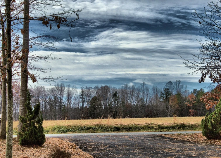 a red fire hydrant sitting on the side of a road, inspired by Dwight William Tryon, flickr, panorama view of the sky, strange trees and clouds, fur hdr, visible from afar!!