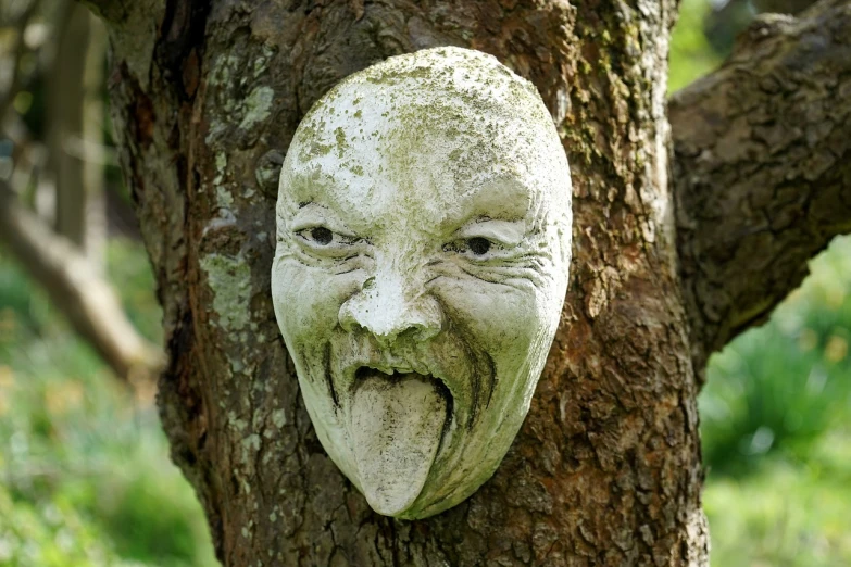 a stone mask hanging on the side of a tree, by Robert Brackman, concrete art, gaping mouth, charming expression gesicht, l vampire, giddy smirk