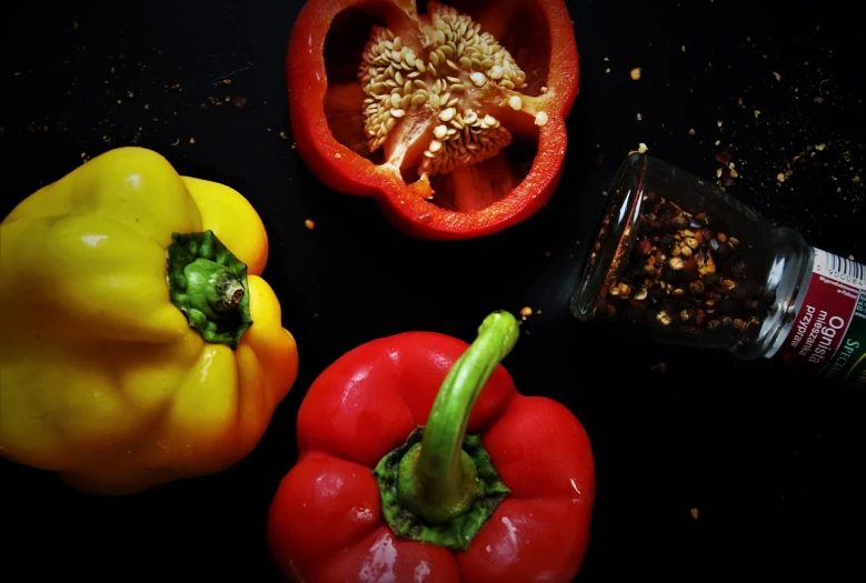 a couple of peppers sitting on top of a table, a picture, by Anna Haifisch, flatlay, bright on black, 🦩🪐🐞👩🏻🦳, grain”