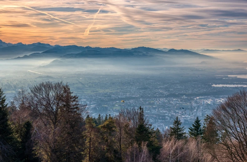 a view of a city from the top of a mountain, a picture, by Karl Stauffer-Bern, shutterstock, city mist softlight, forest in the background, mount olympus, nice colors