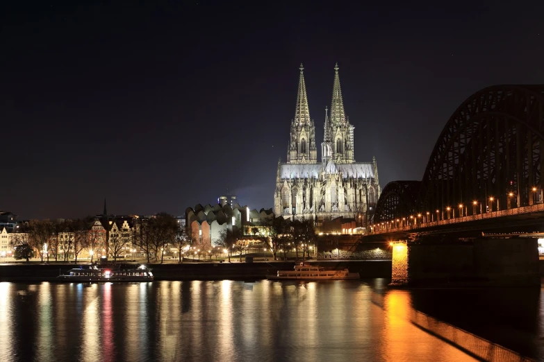 a large cathedral towering over a river next to a bridge, by Jakob Gauermann, shutterstock, photo taken at night, german, koyaanisqatsi, usa-sep 20