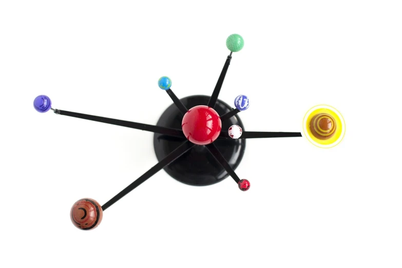 a close up of a clock on a white surface, concept art, by Joe Bowler, kinetic art, where the planets are candy, classic 3 d model of molecule, mars black, midcentury modern