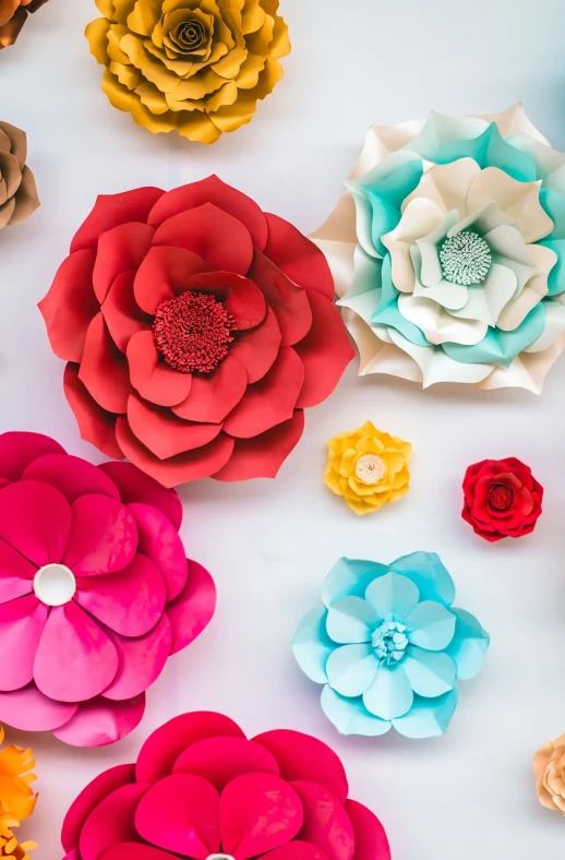 a bunch of paper flowers sitting on top of a table, by Murakami, pexels, red and teal and yellow, floral bling, wall paper, pink flowers