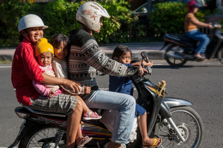 a group of people riding on the back of a motorcycle, by I Ketut Soki, flickr, with a kid, square, stock photo
