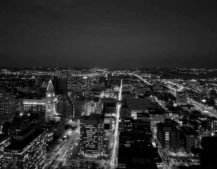 a black and white photo of a city at night, by Andrew Domachowski, capital plaza, looking down on the view, high quality photo, twilight ; wide shot