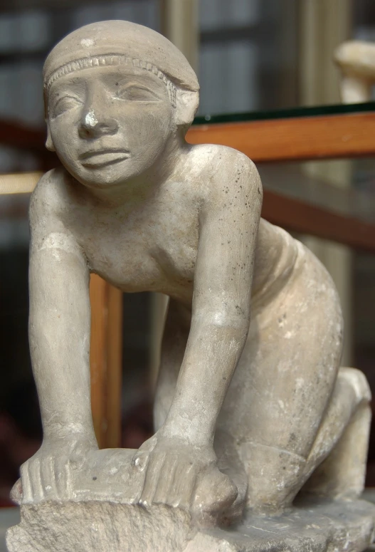 a close up of a statue of a person on a rock, by Hans Fischer, flickr, fine art, egyptian style, young child, bent - over posture, museum photo