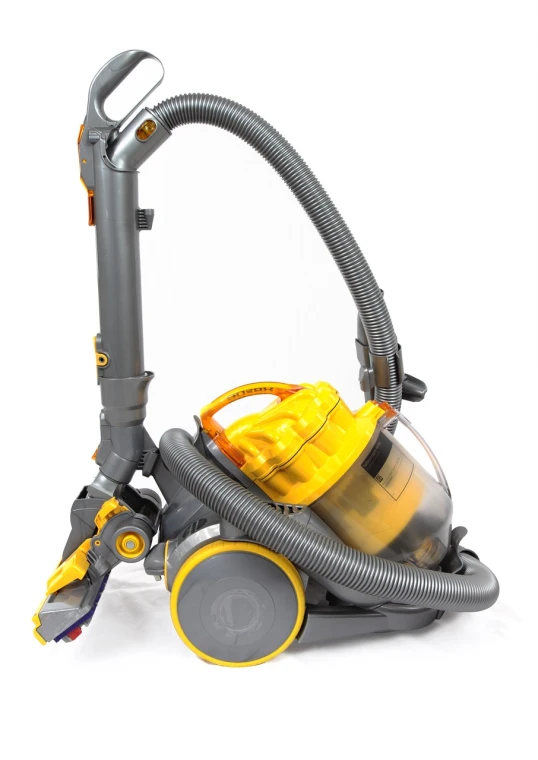 a close up of a vacuum cleaner on a white surface, a stock photo, by Viktor de Jeney, shutterstock, silver and yellow color scheme, highly detailed product photo, thailand, carpet