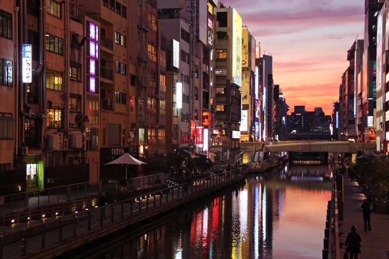 a river running through a city next to tall buildings, inspired by Kōno Michisei, flickr, sōsaku hanga, sunsetting color, kumamoto, canal, 24mp