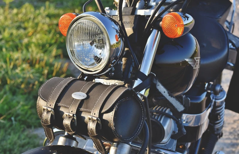 a close up of the headlight of a motorcycle, a picture, by Thomas Häfner, pixabay, photorealism, carrying a saddle bag, summer setting, with big chrome tubes, high res photo