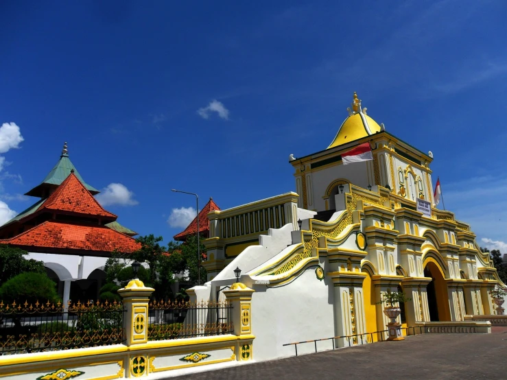 a yellow and white building with a red roof, inspired by I Ketut Soki, tall golden heavenly gates, photo taken with canon 5d, church, museum photo