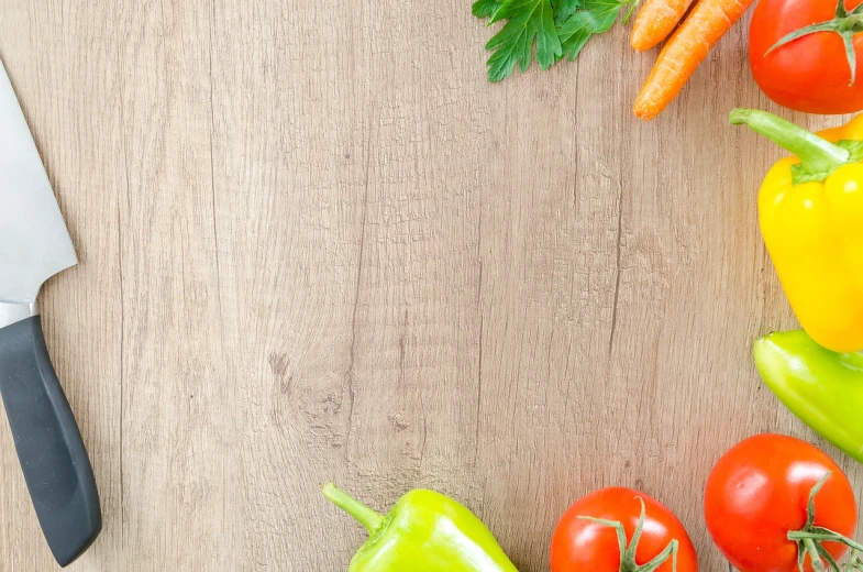 a knife sitting on top of a wooden table next to vegetables, a stock photo, pexels, orange and green power, panorama, viewed from above, multi - coloured