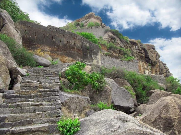 the steps lead up to the top of the mountain, samikshavad, background fortress, rocky foreground, with vegetation, biopic