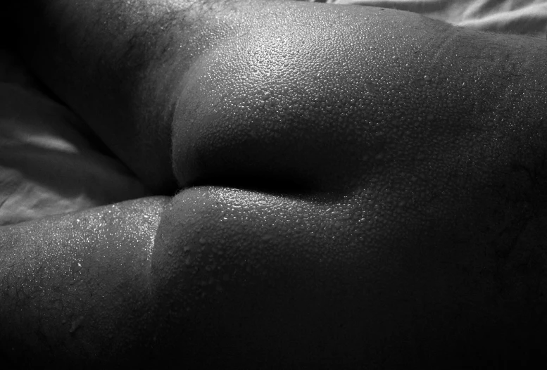 a close up of a person laying on a bed, a stipple, inspired by Edward Weston, flickr, ebony skin, bum, extreme backlighting, fleshy musculature