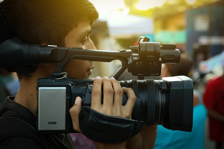 a close up of a person holding a camera, a picture, big film production, journalist photo, shot at golden hour, cctv footage of a movie set