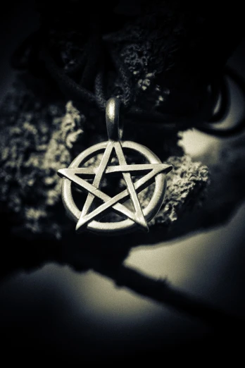 a black and white photo of a pentagram pentagram pentagram pentagram pentagram pentagram pentagram pentagram pentagram pentagram pen, a macro photograph, by Niko Henrichon, pexels, gothic art, pendant, close up shot of an amulet, miniature product photo, alchemical still made from clay