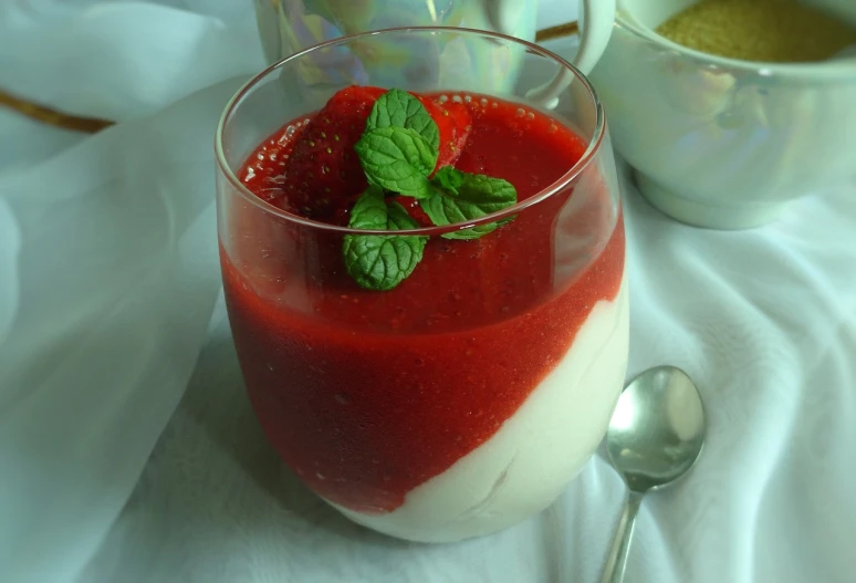 a dessert sitting on top of a table next to a cup of coffee, inspired by Jan Stanisławski, pixabay, red and white color theme, strawberry ninja, with clear glass, jelly - like texture