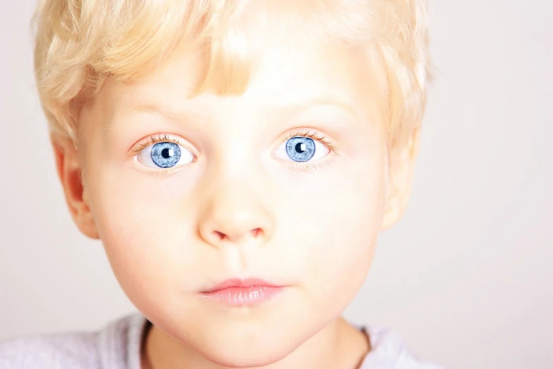 a close up of a child with blue eyes, a photo, blue eyes and blond hair, hyper realistic color photo, high key detailed, prize winning color photo