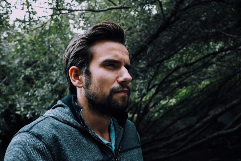 a man with a beard standing in front of a tree, a picture, unsplash, orelsan, headshot profile picture, ultra settings, production still