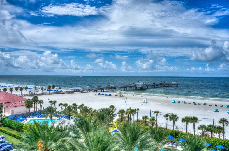 a view of a beach with palm trees and a pier, a stock photo, by John Luke, shutterstock, bauhaus, downtown jacksonville florida, wide high angle view, listing image, postprocessed)