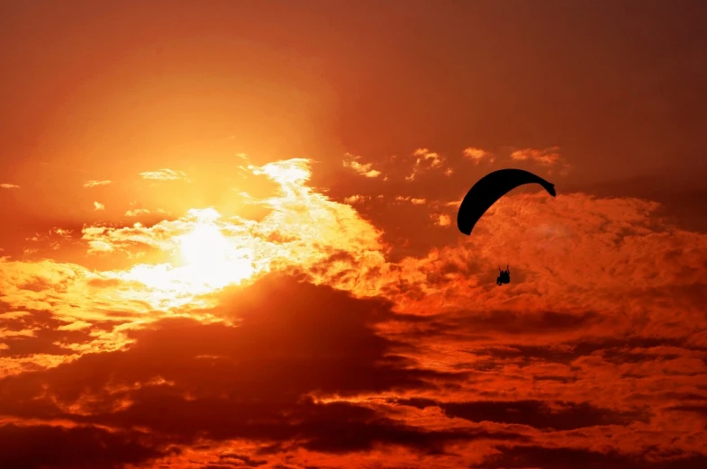 a person that is flying a kite in the sky, a picture, romanticism, orange sun set, parachutes, albuquerque, descending from the heavens