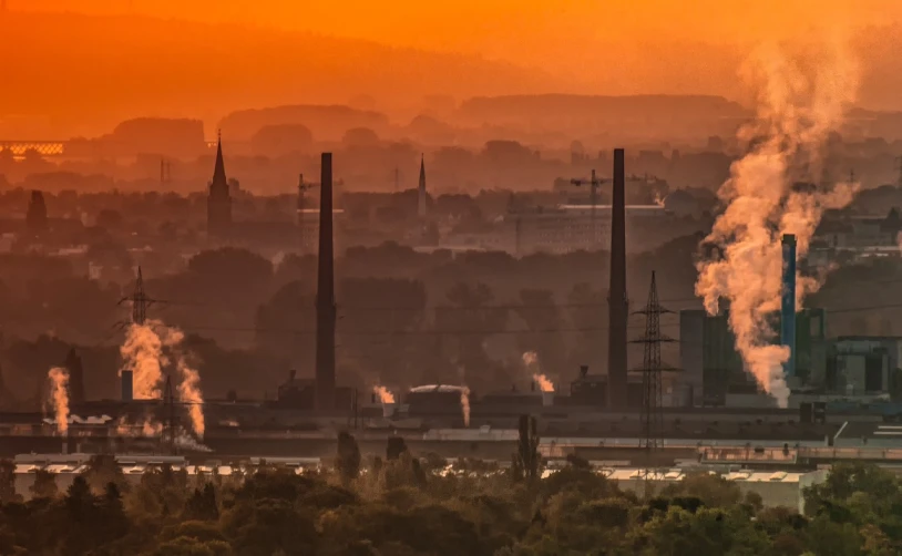 a factory with a lot of smoke coming out of it, by Thomas Häfner, shutterstock, romanticism, vista of a city at sunset, germany. wide shot, heat haze, landscape of flat wastelands