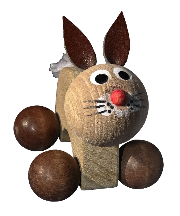 a wooden toy made to look like a bunny, a digital rendering, inspired by Fritz Baumann, pixabay contest winner, mingei, red nose, highly detailed picture, on black background, chocolate