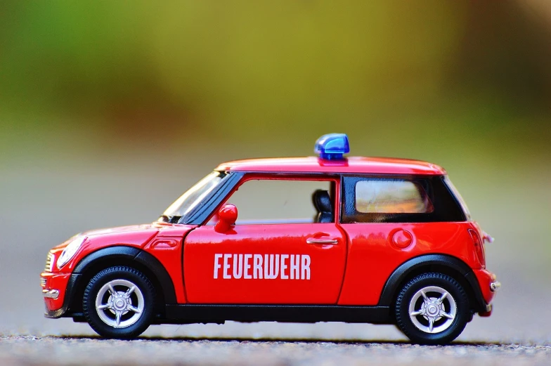 a red toy car with a blue light on top, by Hans Schwarz, trending on pixabay, fireman, mini-skirt, finely detailed car, header text”