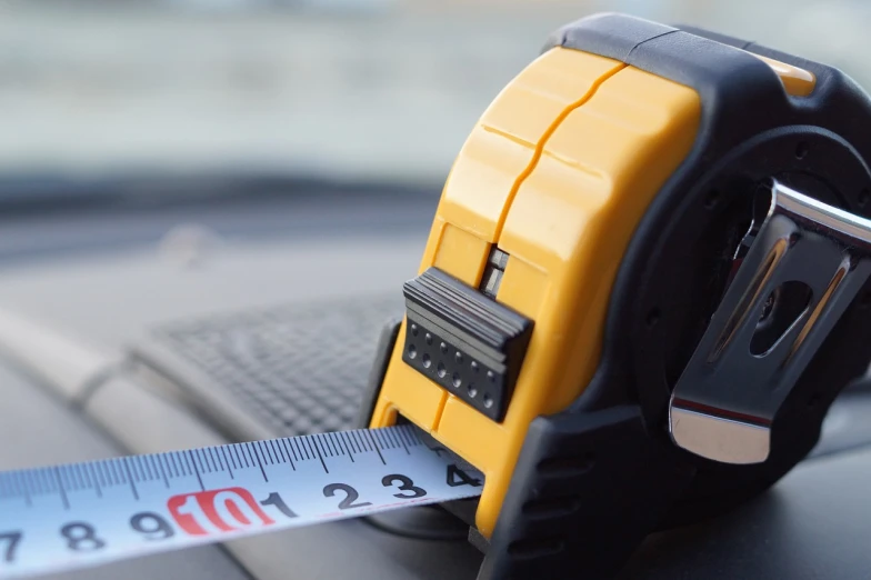 a tape measure on the dashboard of a car, by Stefan Gierowski, les automatistes, professional, banner, blog-photo, construction