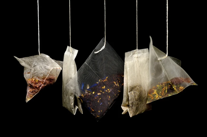 three bags of tea hanging from strings, pexels, process art, on black background, high res photo, iv drip, diverse