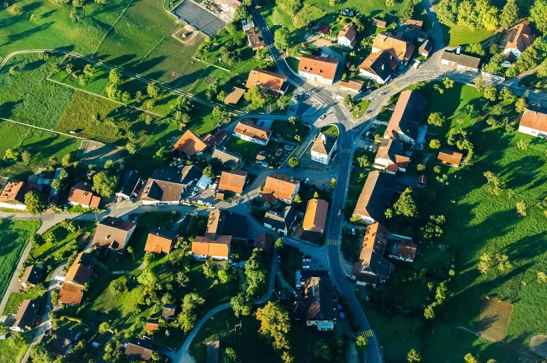 an aerial view of a small town surrounded by trees, by Franz Hegi, shutterstock, bottom angle, high angle uhd 8 k, villages, overhead sun