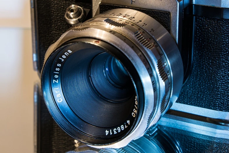 a close up of a camera on a table, a macro photograph, by Hans Schwarz, flickr, carl zeiss 8 5 mm vintage lens, highly detailed photograph, studio medium format photograph, detailed photograph high quality