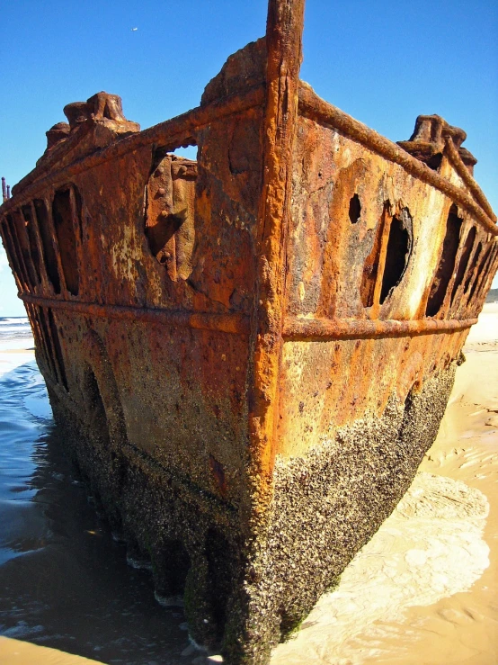 a rusted ship sitting on top of a sandy beach, a portrait, by Alexander Robertson, flickr, viewed from below, stern face, myrtle, impressive detail : 7