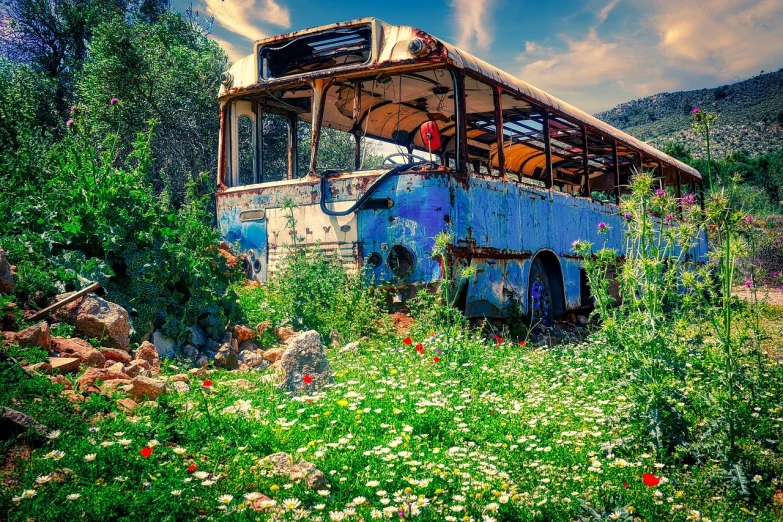 an old bus that is sitting in the grass, a colorized photo, by Micha Klein, trending on pixabay, fantastic realism, greek fantasy panorama, post apocalyptic theme park, humanoids overgrown with flowers, bright blue