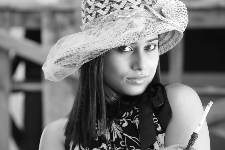 a woman wearing a hat and holding a cell phone, a black and white photo, inspired by irakli nadar, pixabay contest winner, fine art, indian girl with brown skin, dressed in a lacy, sigma 85/1.2 portrait, portrait of a cute woman
