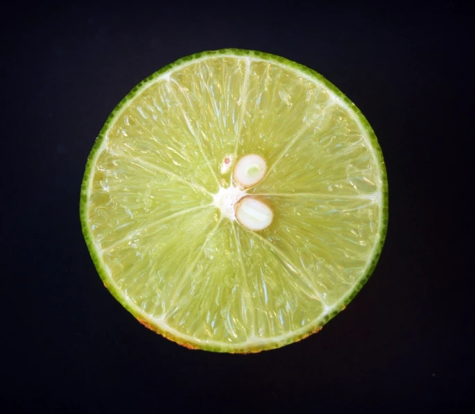 a slice of lime sitting on top of a table, by Jan Rustem, pexels, hyperrealism, underside, luminescence，highly detailed, top - down photo, brimstone