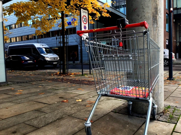 a shopping cart sitting on the side of a street, by Oskar Lüthy, flickr, realism, during autumn, munich, afp, wide shot photo
