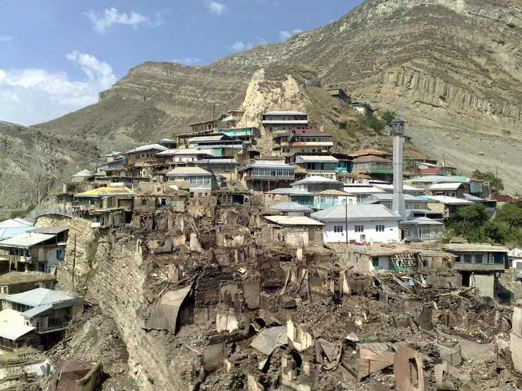 a group of houses sitting on top of a mountain, a picture, dau-al-set, deteriorated, ash thorp khyzyl saleem, landslides, city on a hillside