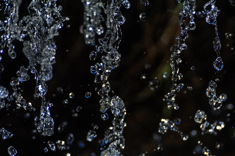 a close up of a bunch of water droplets, by Jan Rustem, renaissance, falling water, some chaotic sparkles, background ( dark _ smokiness ), vines hanging over the water