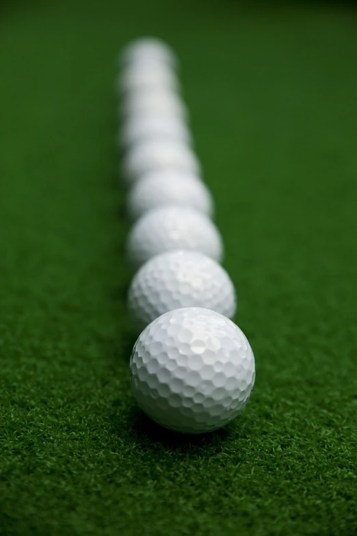 a row of golf balls sitting on top of a green field, inspired by Shirley Teed, happening, smooth edges, 4 0 mm, carpet, performance