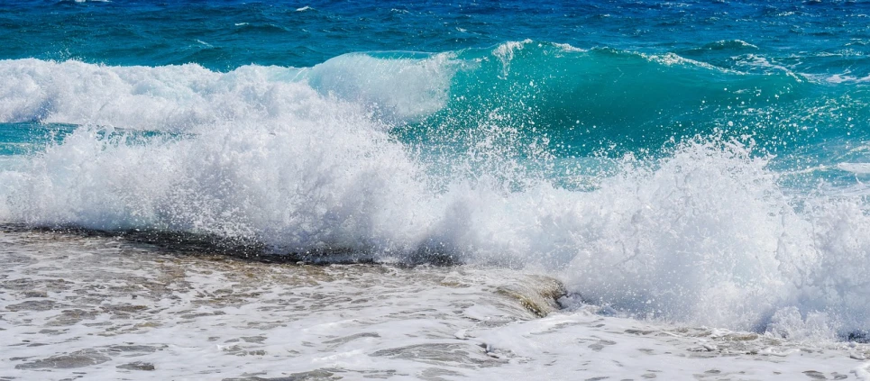 a man riding a wave on top of a surfboard, pexels, fine art, waves crashing at rocks, turqouise, glistening seafoam, blue crashing waves